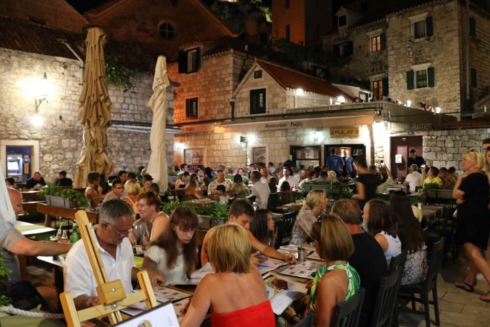 Diners flick through menus on the trg in front of Restaurant Pulziz in Omiš Old Town. © Marc Rowlands 