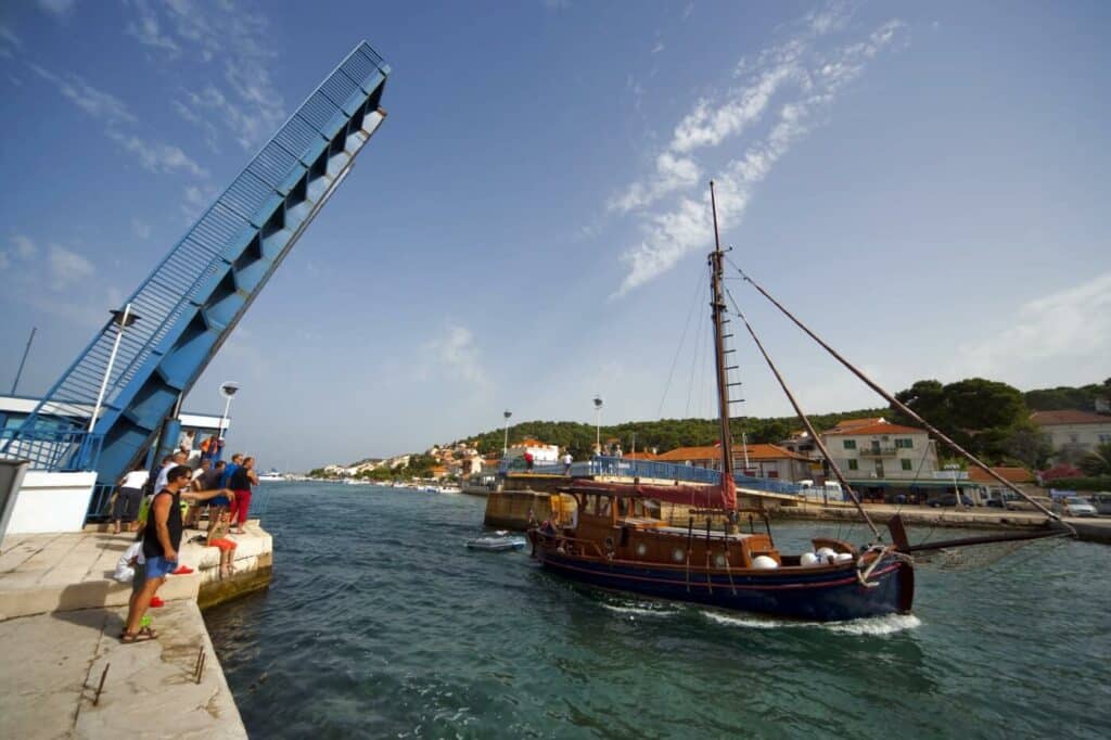 Sailing under the bridge in Tisno, a traditional wooden fishing boat. You can find out how they're made at the museum in Betina