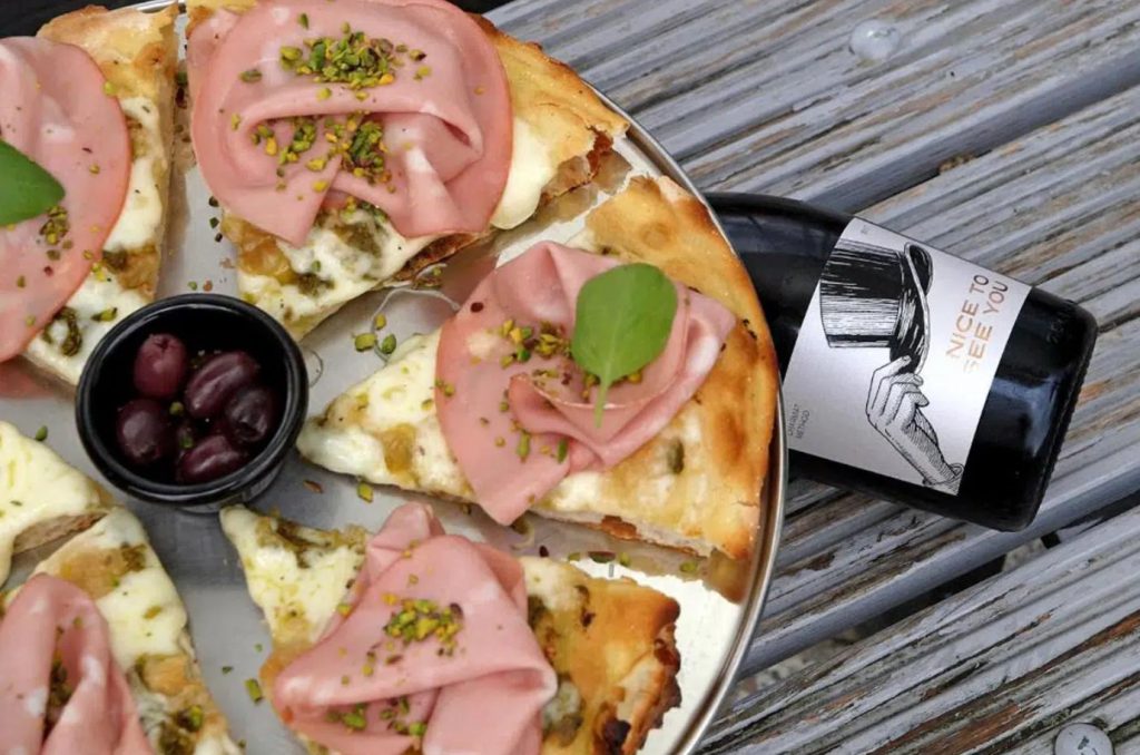 Image of a pizza and Enosophia Winery Nice To See You Sparkling Wine