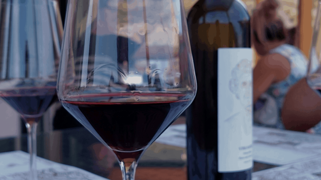 Image of a red wine glass served in a Vislander Winery tasting room