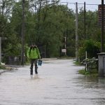 Slovenia thanks Croatia, image of man walking through flooded area in Croatia